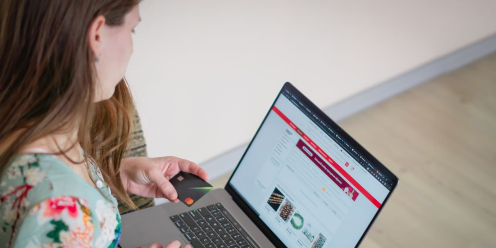 Moça com notebook no colo e analisando a tela